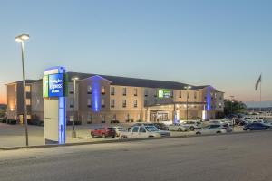 a parking lot with cars parked in front of a building at Holiday Inn Express & Suites N Waco Area - West, an IHG Hotel in West