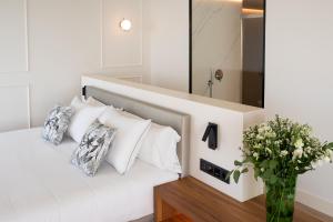 a bedroom with a white bed with a vase of flowers at Arrecife Gran Hotel & Spa in Arrecife
