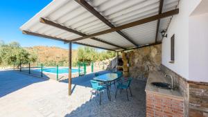 Ríogordo的住宿－Casa La Molina Riogordo by Ruralidays，一个带桌椅的庭院和一个游泳池