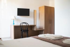 a bedroom with a bed with a desk and a chair at Musa B&B in Taranto