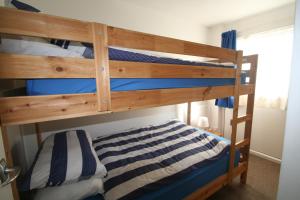 1 dormitorio con 2 literas con sábanas azules y blancas en Freshwater Bay Holiday Cottages, en Pembroke