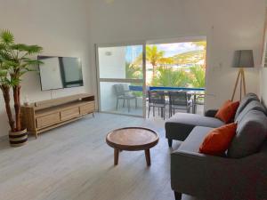 a living room with a couch and a tv and a table at Appartement neuf en plein cœur de Philipsburg in Philipsburg