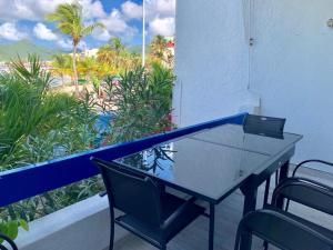 un tavolo e sedie su un balcone con vista sulla spiaggia di Appartement neuf en plein cœur de Philipsburg a Philipsburg