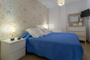 una camera con letto blu e piumone blu di Luxury apartment in front of the beach a Melenara