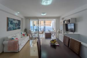 un soggiorno con divano bianco e tavolo di Luxury apartment in front of the beach a Melenara