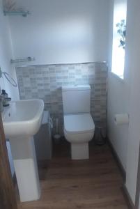 a bathroom with a white toilet and a sink at The LITTLE HOUSE in HULL in Hull