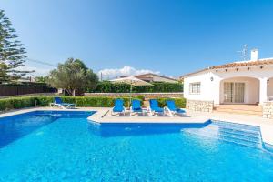 サン・リュイスにあるVilla Arena Blancaの青い椅子付きのスイミングプール、家