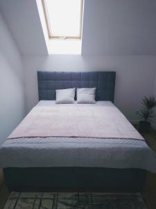 a large bed in a room with a window at Apartament Bukowinka in Krośnica