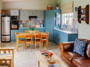 cocina y sala de estar con mesa y sillas en Cape Cottages, en Bergvliet