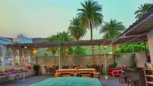 a patio with tables and chairs and palm trees at Hotel Bundi House in Būndi
