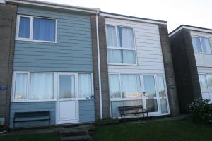 a house with two benches in front of it at Freshwater Bay Holiday Cottages in Pembroke