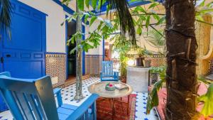 a room with blue chairs and a table and trees at Villa El Patio Andaluz Velez-Malaga by Ruralidays in Vélez-Málaga