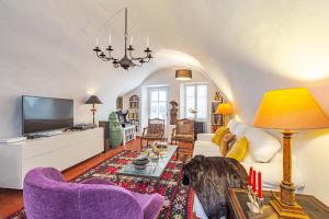 uma sala de estar com um sofá e uma televisão em La Maison du Prince em Grimaud