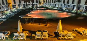 an empty pool with chairs and umbrellas in a hotel at FBC Fortuny Resort - Adults Only in Maspalomas