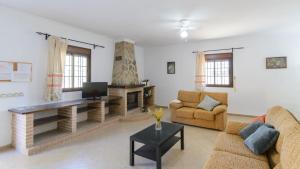 een woonkamer met 2 banken en een tv bij Casa San Nicolas Algar by Ruralidays in Algar