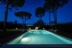 uma piscina iluminada à noite em Villa Ines 19th century atmosphere near Lucca em Altopascio