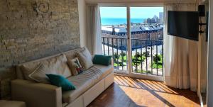 a living room with a couch and a large window at EdenMDQ in Mar del Plata