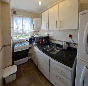 a small kitchen with a sink and a stove at EdenMDQ in Mar del Plata