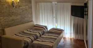 a living room with two beds and a television at EdenMDQ in Mar del Plata