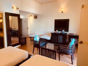 a hotel room with a bed and a table and a television at Hotel Glitz Jaipur in Jaipur +81 photos
