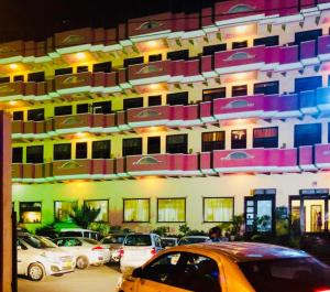 a large building with cars parked in a parking lot at Hotel Glitz Jaipur in Jaipur