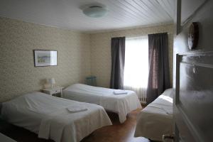 a hotel room with two beds and a window at Kauppilan Matkailutalo in Ikaalinen +2 photos