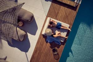 a woman sitting in a boat next to a swimming pool at Contessina Hotel in Tsilivi
