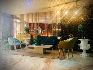 a living room with a blue couch and chairs at Hotel Marqués de Santillana in Torrelavega