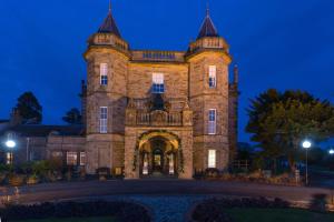 a large building with a clock on the front of it at Dalmahoy Hotel & Country Club in Edinburgh