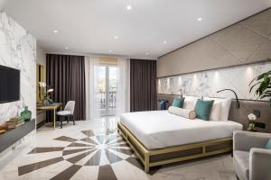 a hotel room with a large bed and a tv at Lure Hotel & Spa - Adults Only in Mellieħa