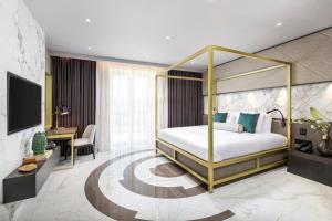 a bedroom with a canopy bed and a desk at Lure Hotel & Spa - Adults Only in Mellieħa