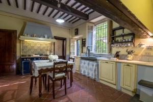 uma cozinha com uma mesa e cadeiras e um lavatório em Villa Ines 19th century atmosphere near Lucca em Altopascio