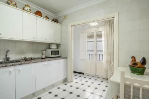 a kitchen with white cabinets and a sink at Casa Romero in Vejer de la Frontera +12 photos