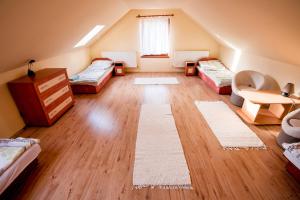 a attic room with two beds and a table at Edelin Country House in Becskeháza