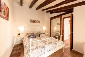 een slaapkamer met een wit bed in een kamer bij Macarena's House in Valldemossa