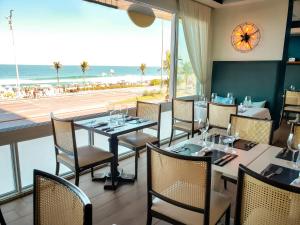 里約熱內盧的住宿－索勒伊帕內馬酒店，一间带桌椅的餐厅,享有海滩美景