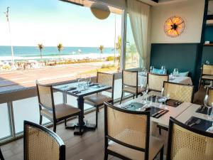 a restaurant with tables and chairs and a view of the beach at Sol Ipanema Hotel in Rio de Janeiro