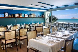 a restaurant with tables and chairs with a view of the ocean at Sol Ipanema Hotel in Rio de Janeiro