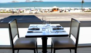 a table with two chairs and a table with wine glasses at Sol Ipanema Hotel in Rio de Janeiro
