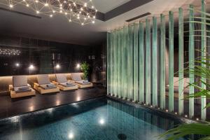 a hotel lobby with a swimming pool and lounge chairs at Lure Hotel & Spa - Adults Only in Mellieħa