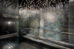 a bathroom with a shower with a brick wall at Lure Hotel & Spa - Adults Only in Mellieħa