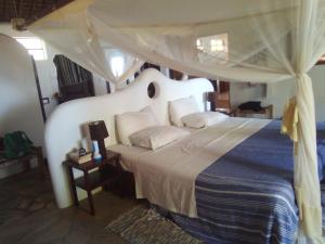 1 dormitorio con 1 cama con dosel en Embedodo Beach House, Ushongo beach, Pangani en Ushongo Mabaoni