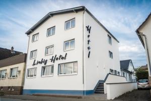a white building with the words happy hotel on it at Liebig Hotel in Ehringshausen