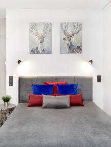 a bedroom with a bed with blue and red pillows at Pearl of the Old Town in Vilnius