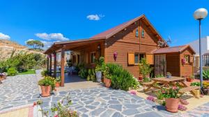 a wooden house with a picnic table and flowers at Casa Alegria Almayate Alto by Ruralidays in Almayate Alto