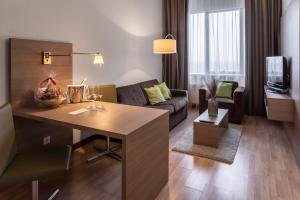 a living room with a couch and a table in a room at Ramada Encore Kyiv in Kyiv