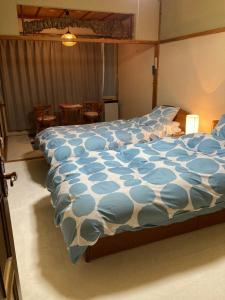 a bedroom with a bed with a blue and white comforter at Bamboo-Hill Sasaoka in Nozawa Onsen