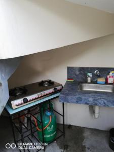 a kitchen counter with a sink and a table at Diaz Residence in Silang