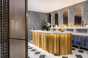 a bar in a hotel with a gold counter at Lure Hotel & Spa - Adults Only in Mellieħa