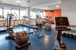 a gym with several treadmills and exercise bikes at Ramada Encore Kyiv in Kyiv